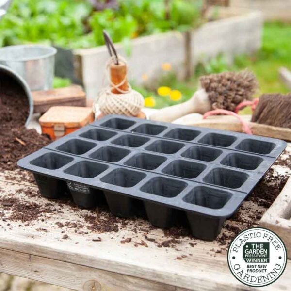 20 cell rubber seed tray on a bench surrounded by compost and seed sowing equipment