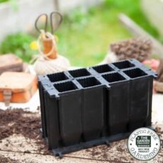 8 deep cell rubber seed tray on a potting bench with seed sowing equipment