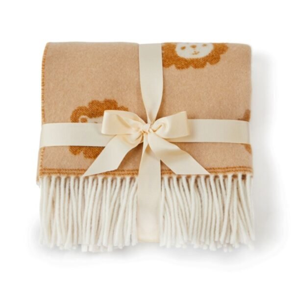 Merino wool baby blanket in brown and cream with lion faces, folded and tied with a cream bow