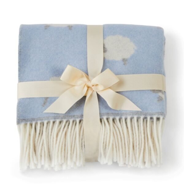 Merino wool baby blanket blue with sheep folded and tied with a cream ribbon showing the creamy white fringe