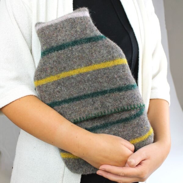 Tweedmill middle opening recycled wool hot water bottle and cover with grey background with yellow and green stripes and green thread blanket stitch