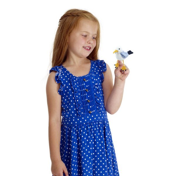 Young girl playing with a Seagull finger puppet facing forward on a white background