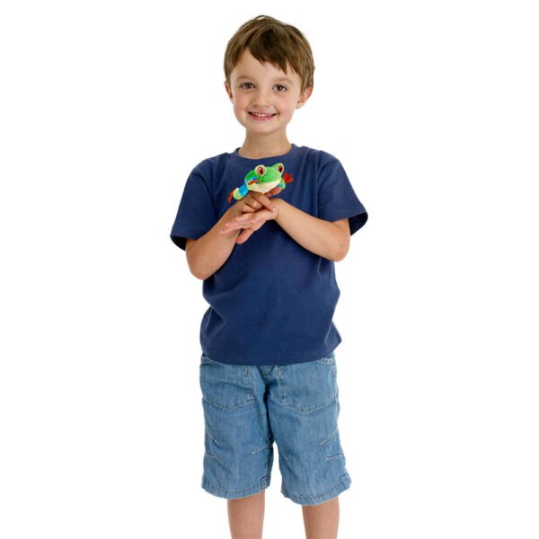Young boy in a blue tshirt and shorts playing with the Tree frog finger puppet in green blue and orange with red eyes on a white background
