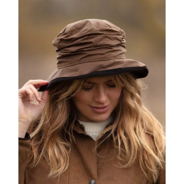 Diana waxed hat in beige being worn by a woman with long blond hair outdoors.