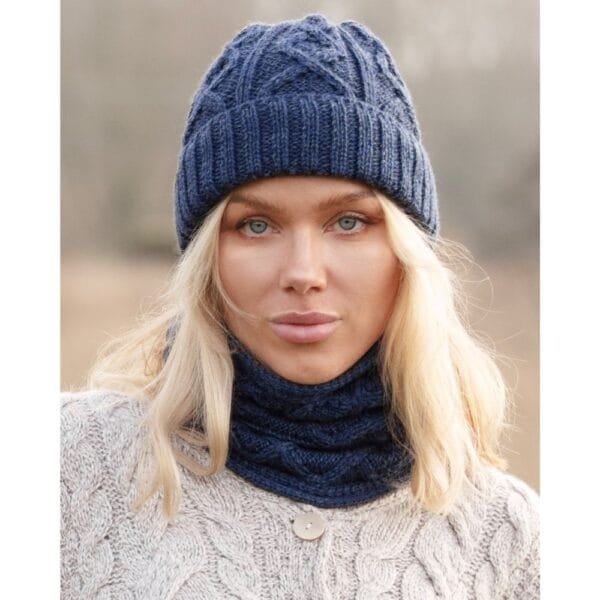 Merino wool hat in Aran knit navy blue on a woman in a white jumper