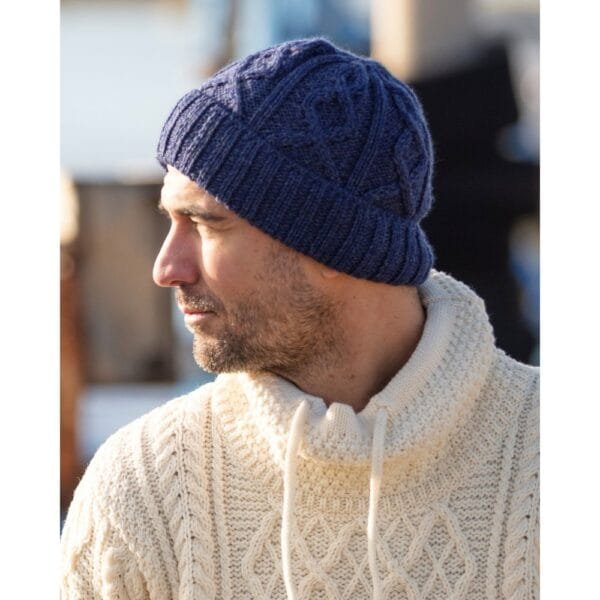 Merino wool hat in Aran knit navy blue on a man in a white jumper