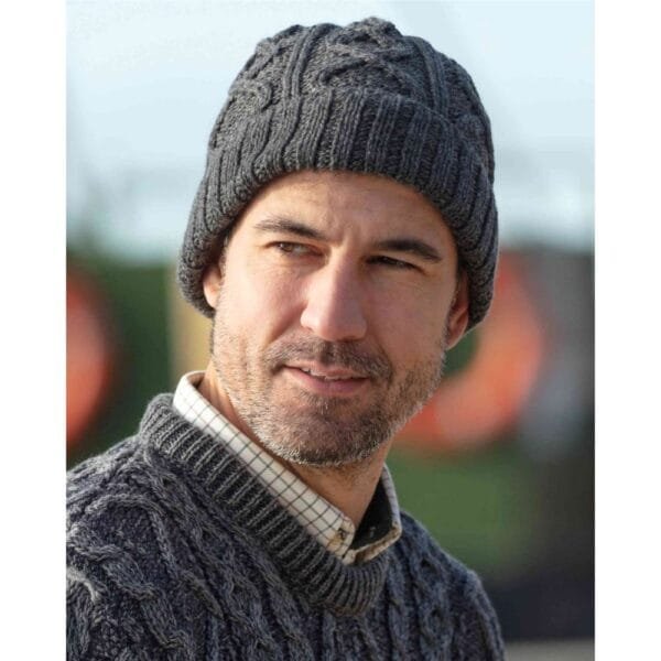 Merino wool hat in Aran knit Slate Grey worn by a man outdoors