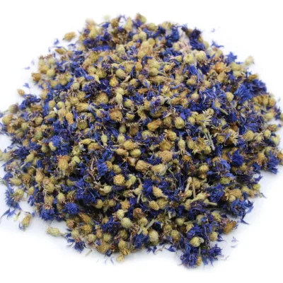 Blue cornflowers dried in a small pile on a white background